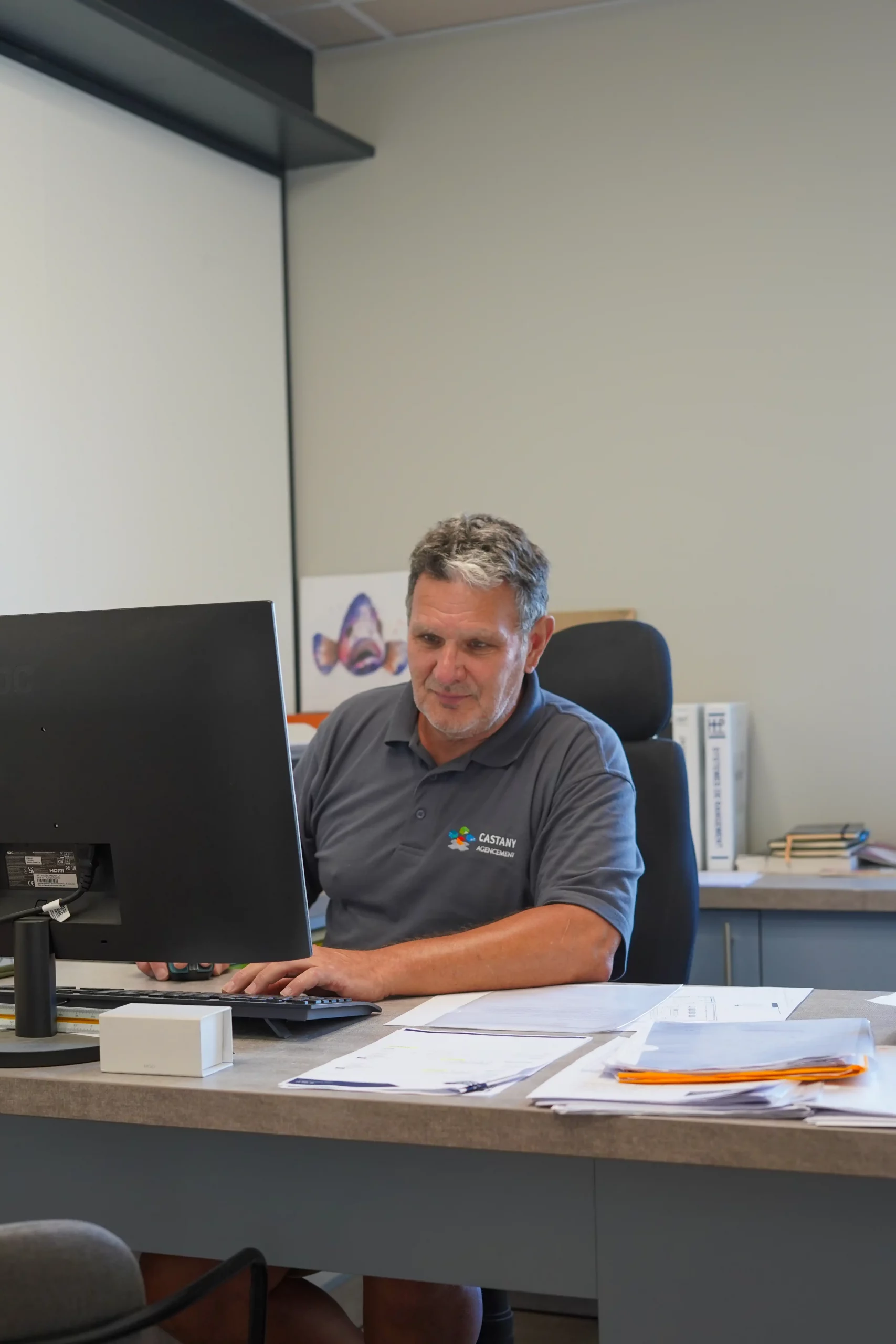 Collaborateur du bureau d'étude Castany Agencement concevant un projet d'agencement sur mesure pour un espace professionnel.