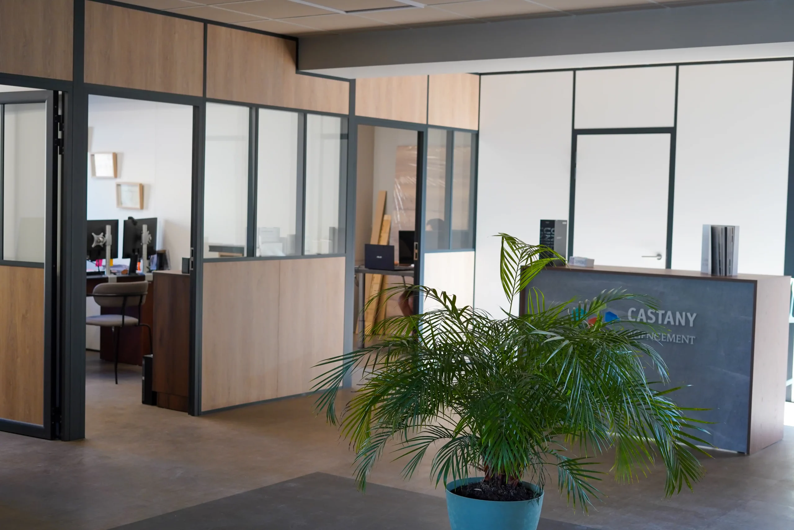 Accueil et bureaux de Castany Agencement, conçus avec des cloisons vitrées et un agencement intérieur sur mesure.