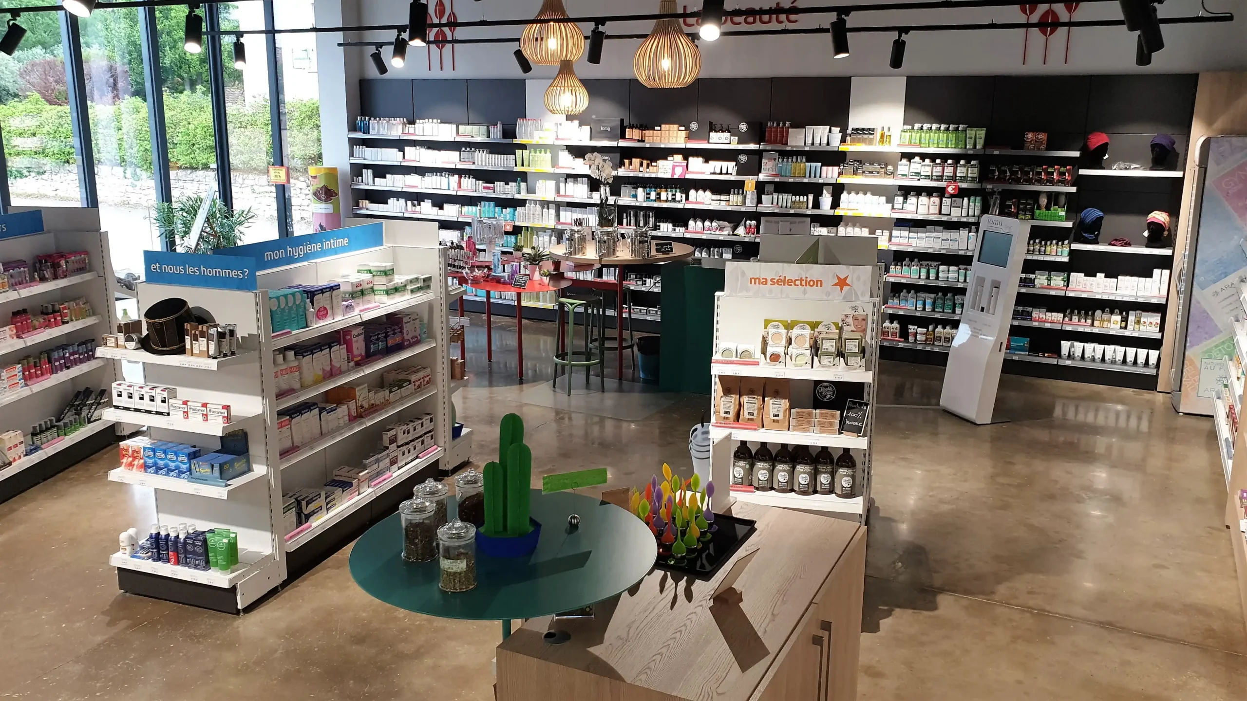 Vue d'ensemble de l'espace de vente de la Pharmacie de Lagnes avec mobilier d'agencement sur mesure réalisé par Castany Agencement.